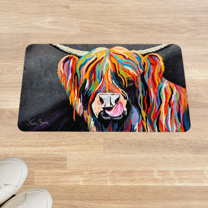 A rectangular floor mat featuring a colorful painted Highland cow portrait, shown on a light wood floor with white shoes partially visible in the lower left corner.